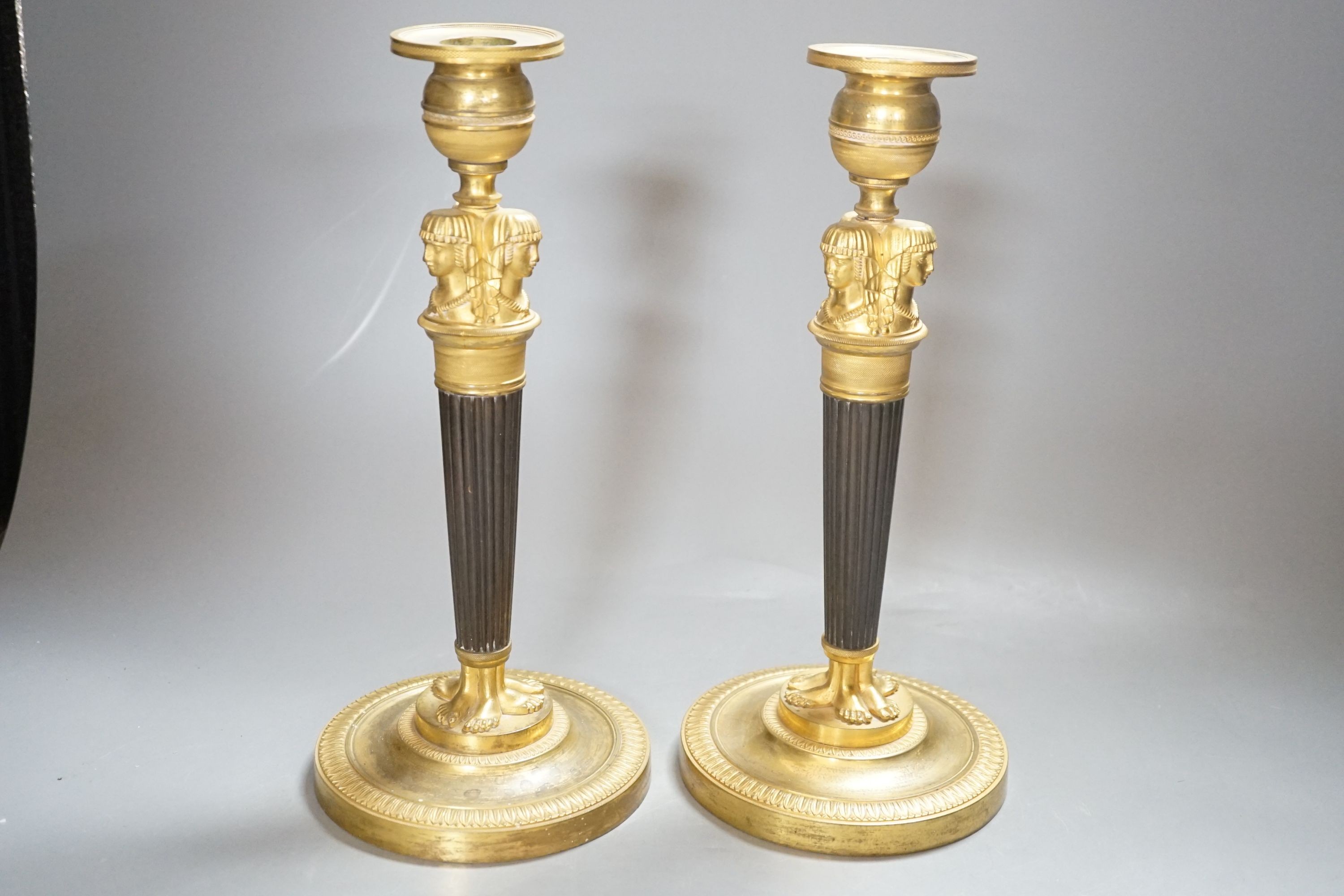 A pair of Empire style bronze and ormolu candlesticks - 29.5cm tall